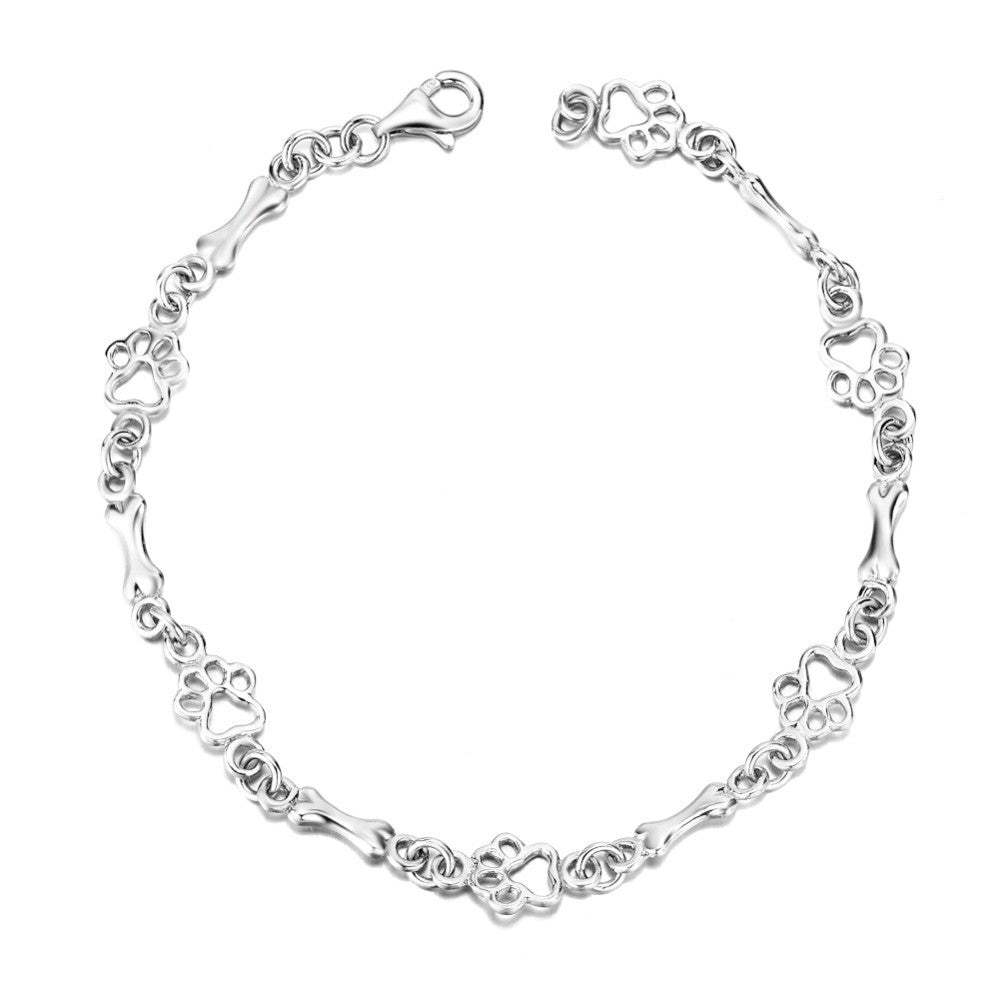 Bracelet avec des pendentifs en forme de patte de chien et d'os en argent